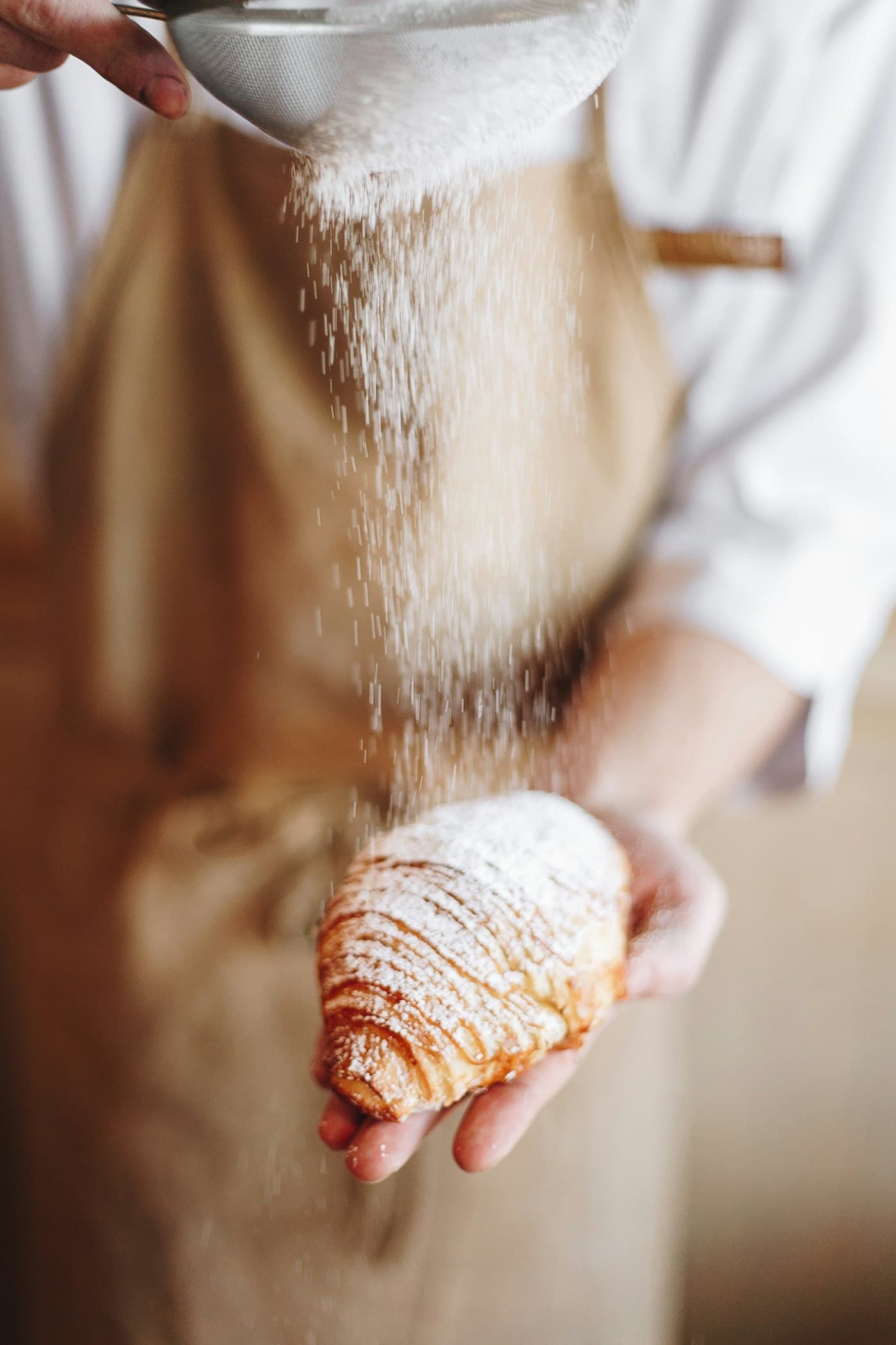 Baker dusting flour over dough